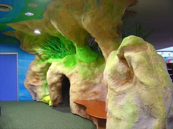 Themed Area - Mt Gambier Library
Inside of the entry to the children's section including redgum seat and crawl through tunnel. The rock form also features a reed bed and moss decorations.
